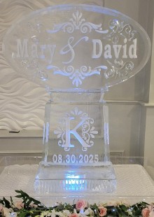 ice matters horizontal oval with snowfilled names and flourish and clear swirls on tall base with fancy snowfilled initial and date